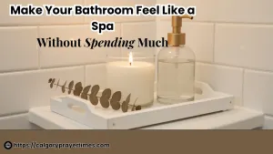 A serene spa-like bathroom with white folded towels, a lit candle, a small plant, and warm lighting