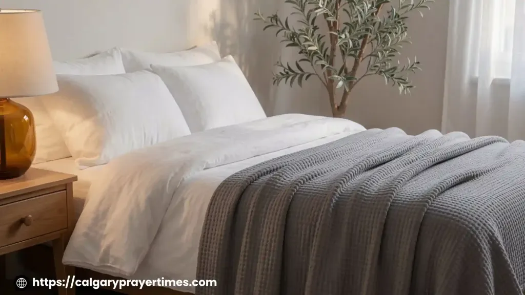 Peaceful bedroom at night with a weighted blanket, warm amber lamp, and herbal tea on the nightstand.
